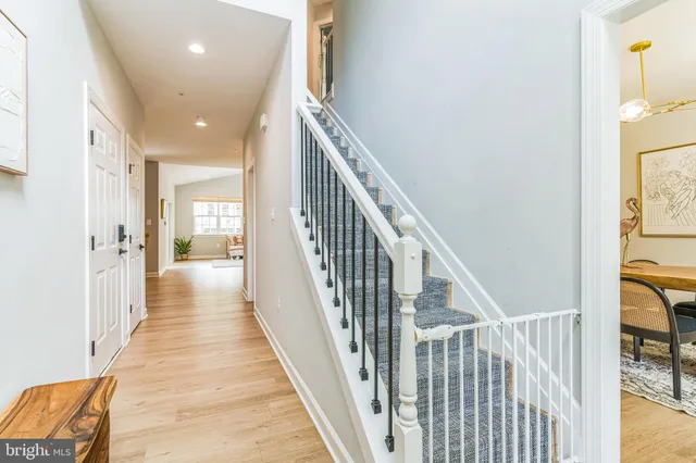 a view of a hallway with wooden floor and staircase