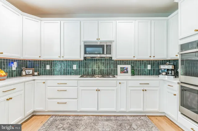 a kitchen with stainless steel appliances granite countertop a stove a sink and a white cabinets