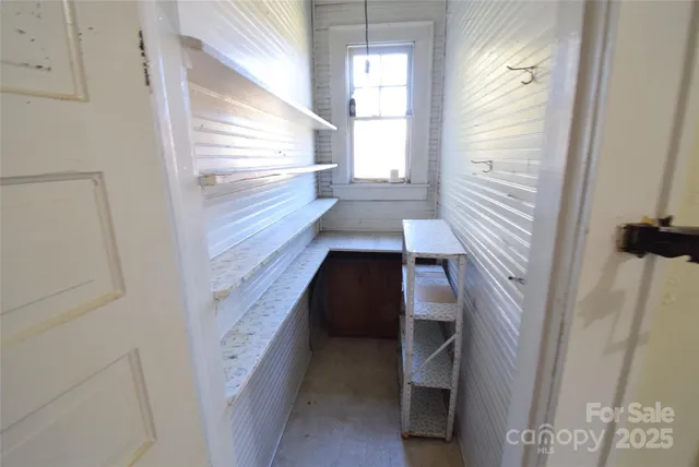 a view of an empty room with a fireplace and a window