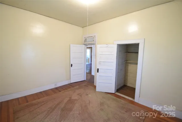 a view of an empty room with a fireplace and a window
