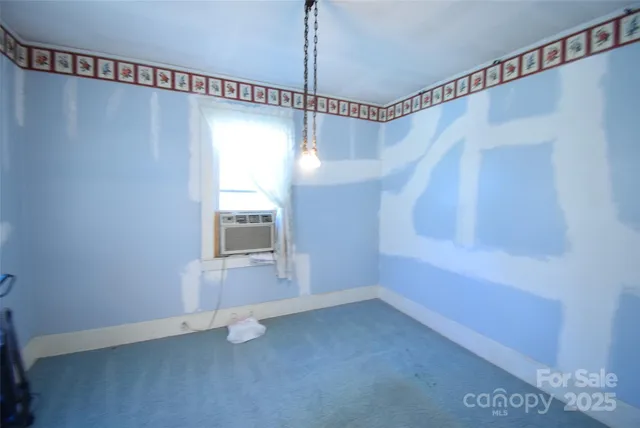 a view of a small space with wooden floor and windows