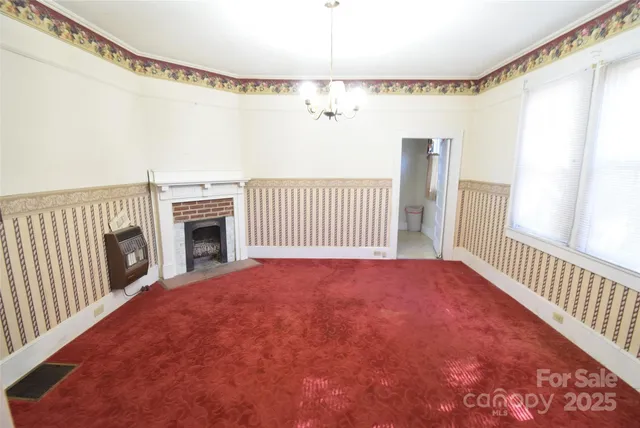a view of a livingroom with a staircase a fireplace and a ceiling fan