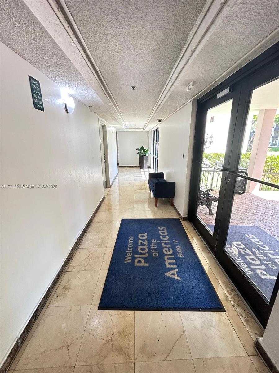 17021 North Bay Road, Unit 322 Sunny Isles Beach, FL 33160 - Photo 14 of 18 a large hall with wooden floor and a rug