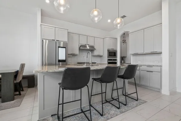 a kitchen with stainless steel appliances granite countertop a sink refrigerator and cabinets