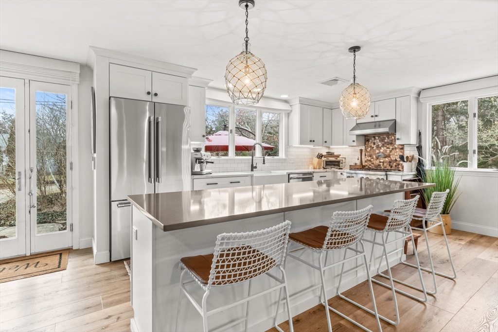 1 Captain Towne Road East Sandwich, MA 02537 - Photo 1 of 35 a very nice looking kitchen with granite countertop a stove a sink and a dining table with chairs
