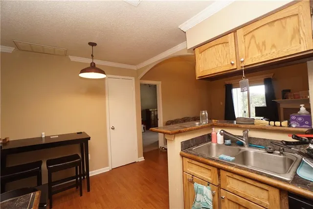 a kitchen with a sink cabinets and wooden floor