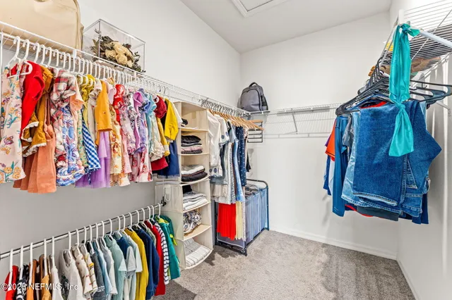a view of walk in closet with clothes