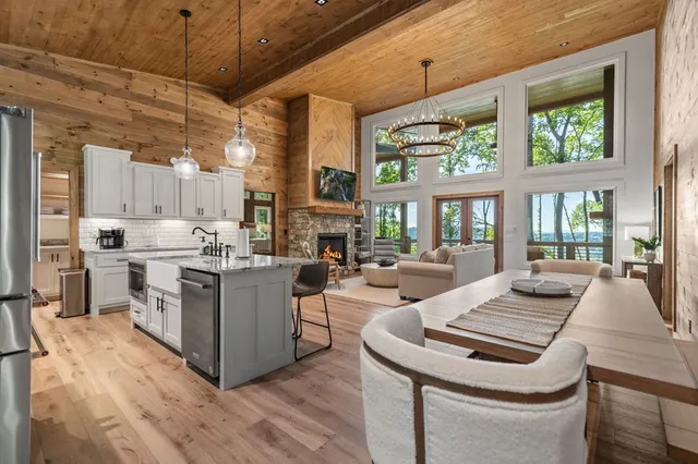 a kitchen with granite countertop a table chairs stainless steel appliances and cabinets