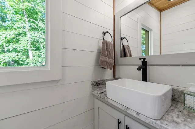 a spacious bathroom with a granite countertop sink and a bathtub
