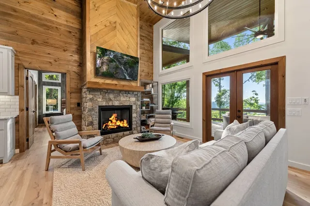 a living room with furniture a fireplace and a floor to ceiling window