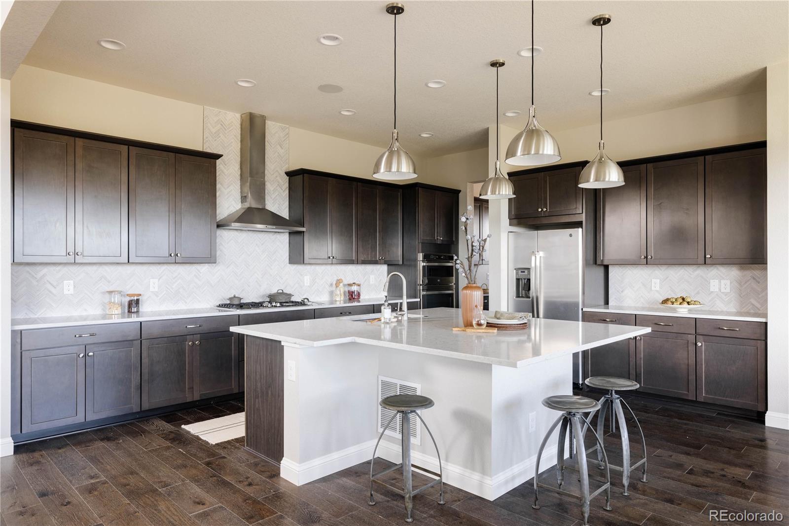 3966 Breakcamp Court Castle Rock, CO 80108 - Photo 12 of 46 a kitchen with stainless steel appliances granite countertop a stove a sink a oven a dining table and chairs