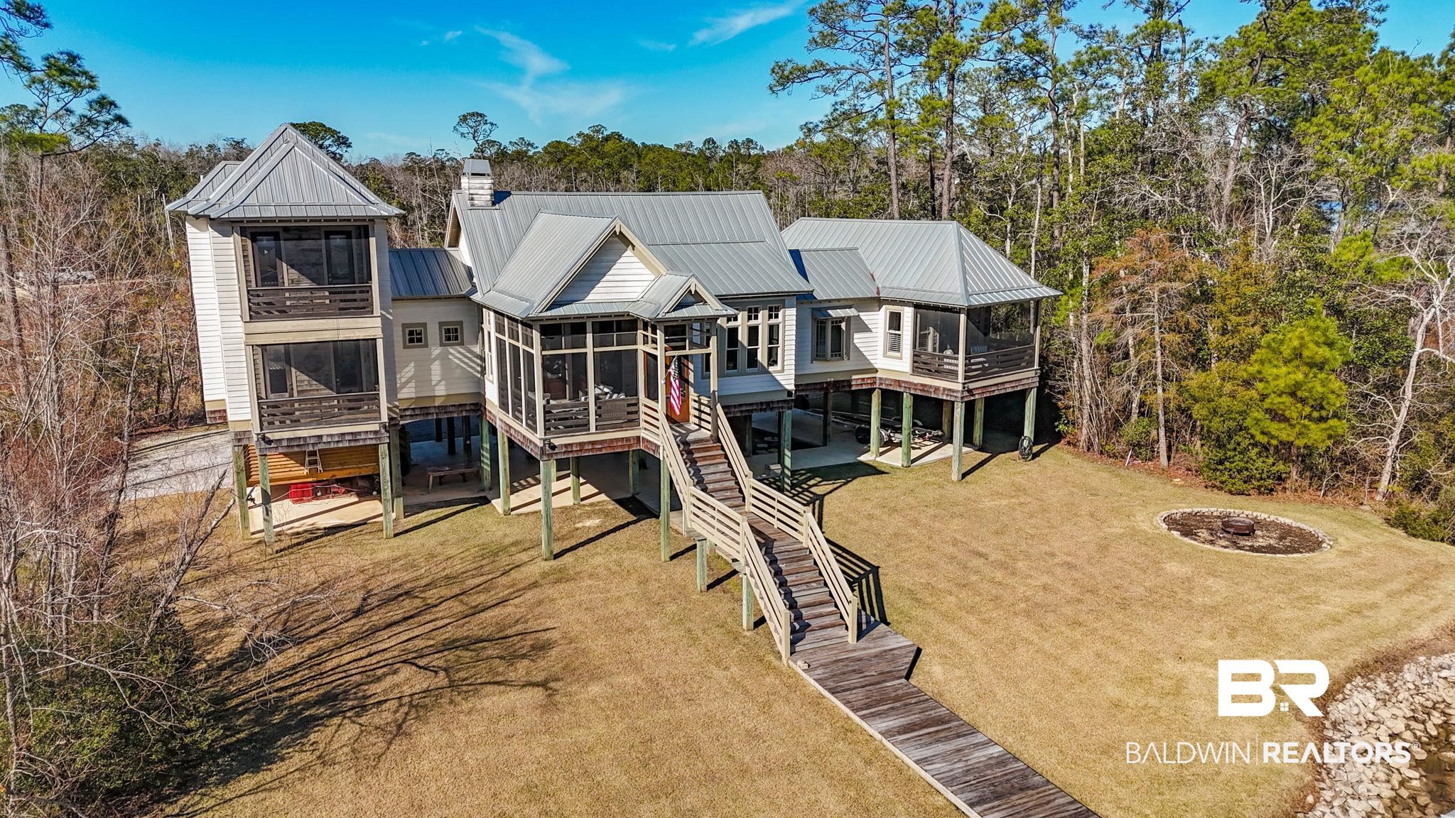 15020 River Road Fairhope, AL 36532 - Photo 43 of 59 Back of house with a deck, a sunroom, a fire pit, and a lawn