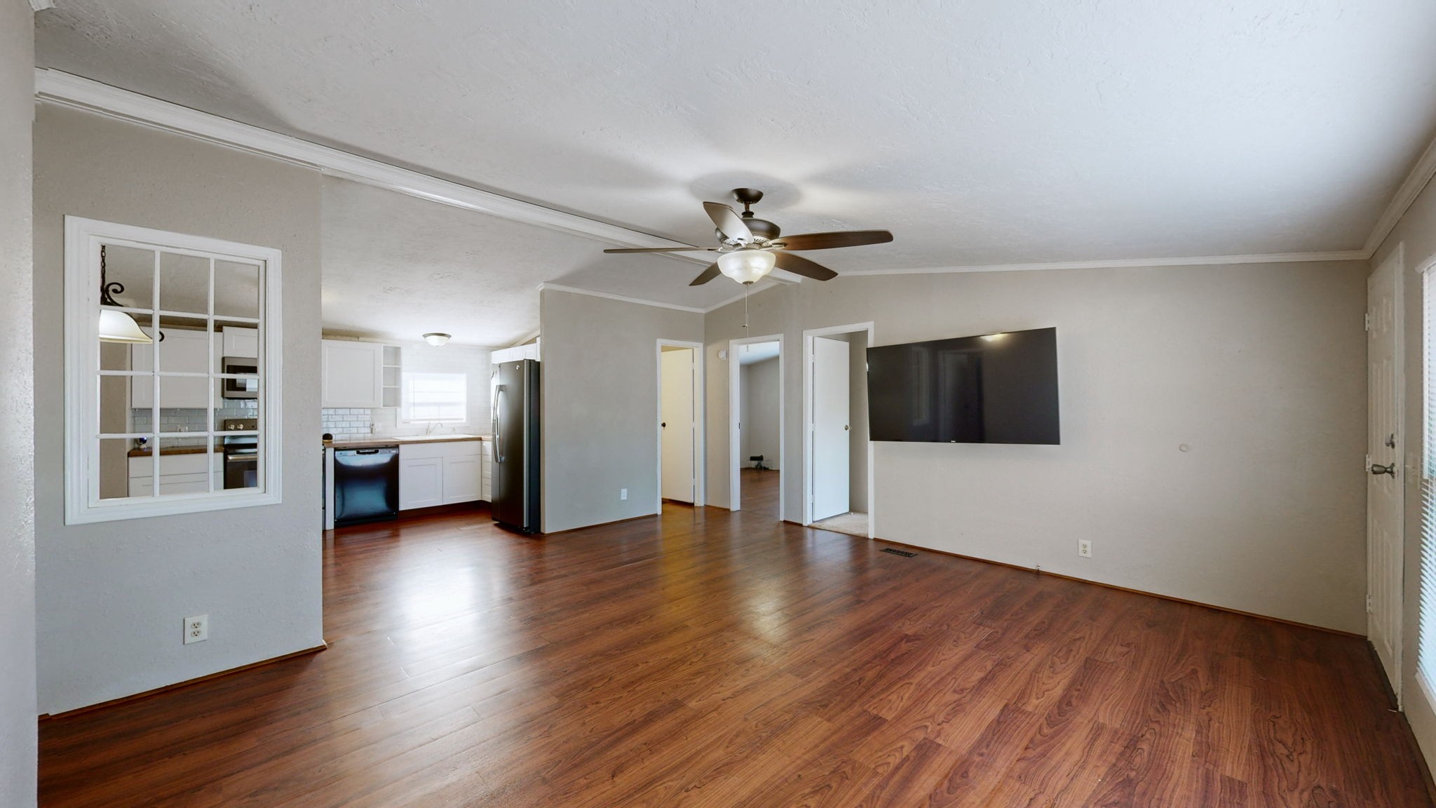 574 Benson Road Manchester, TN 37355 - Photo 6 of 41 a view of an empty room with wooden floor and a kitchen