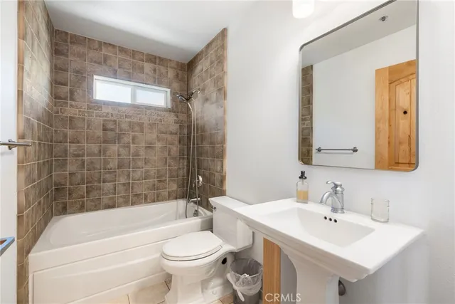 a bathroom with a bathtub a sink a toilet and mirror