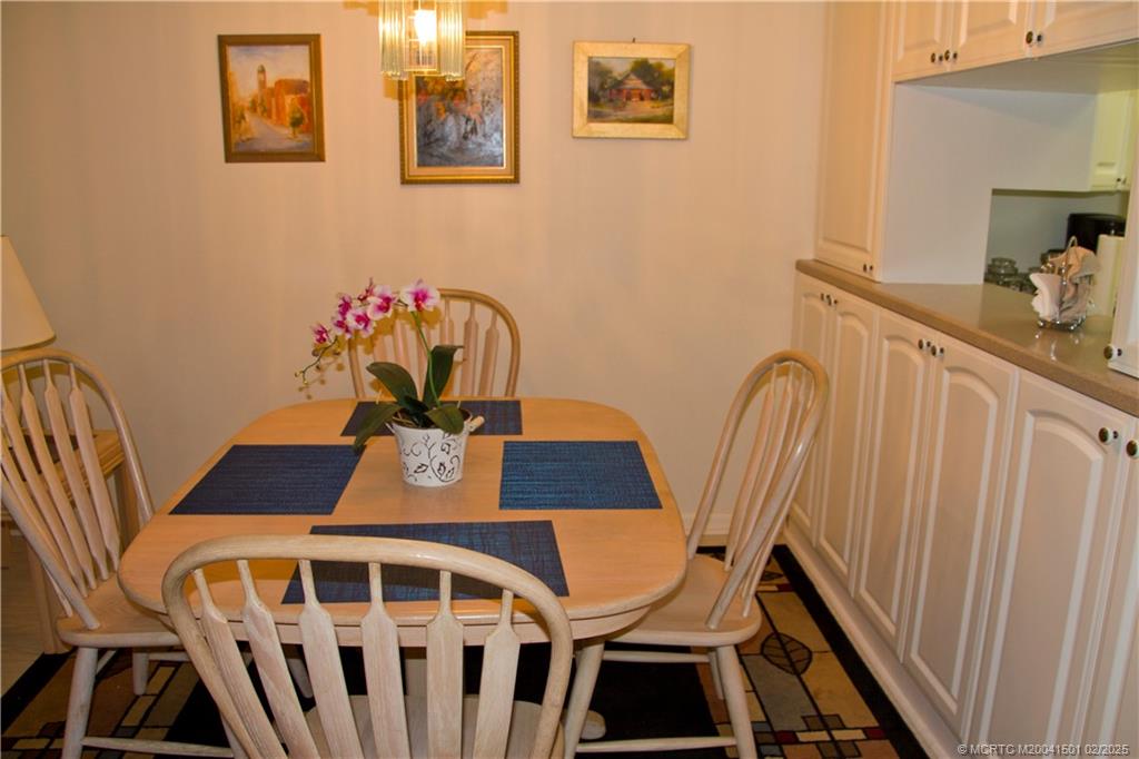 4620 Northeast Sandpebble Trace, Unit 405 Stuart, FL 34996 - Photo 12 of 26 a view of a dining room with furniture and wooden floor