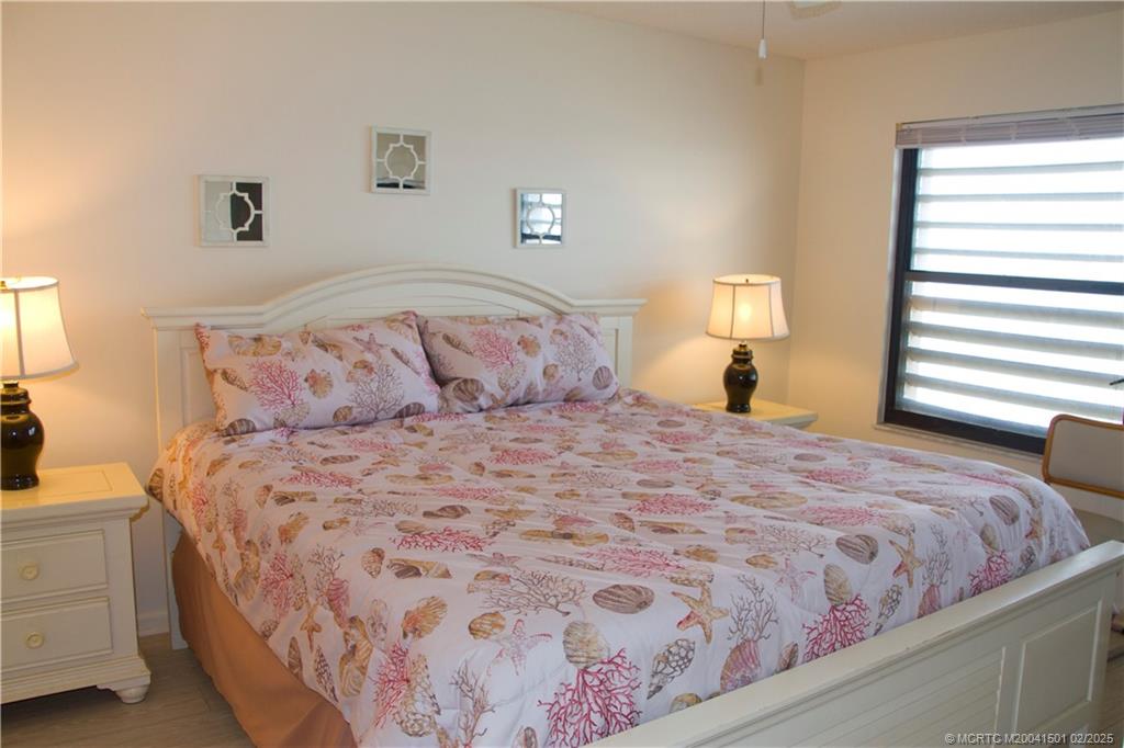 4620 Northeast Sandpebble Trace, Unit 405 Stuart, FL 34996 - Photo 18 of 26 a bedroom with a bed and a night stand