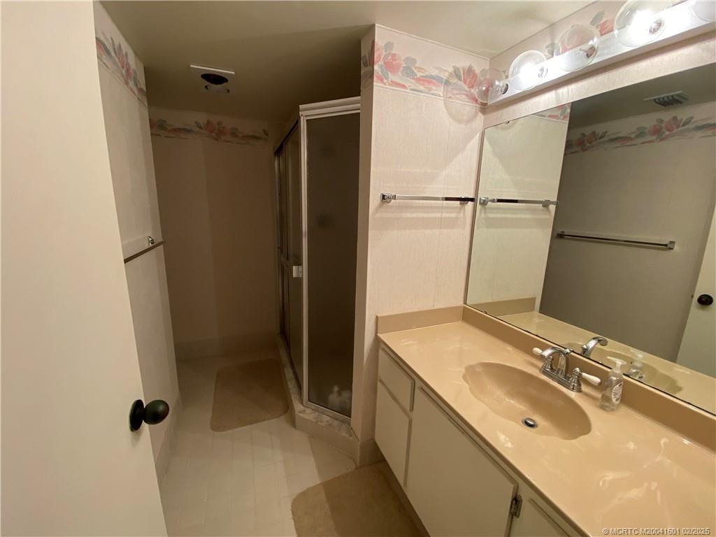 4620 Northeast Sandpebble Trace, Unit 405 Stuart, FL 34996 - Photo 19 of 26 a bathroom with a sink double vanity and shower