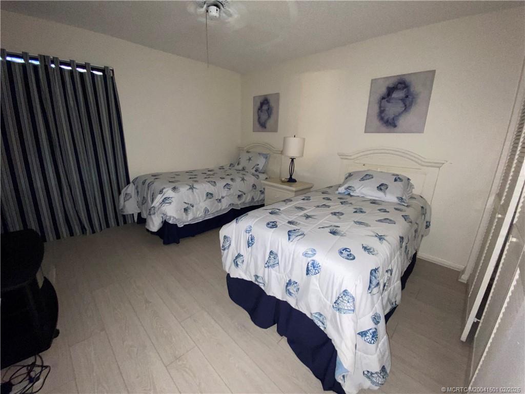 4620 Northeast Sandpebble Trace, Unit 405 Stuart, FL 34996 - Photo 20 of 26 a bedroom with two beds and a dresser