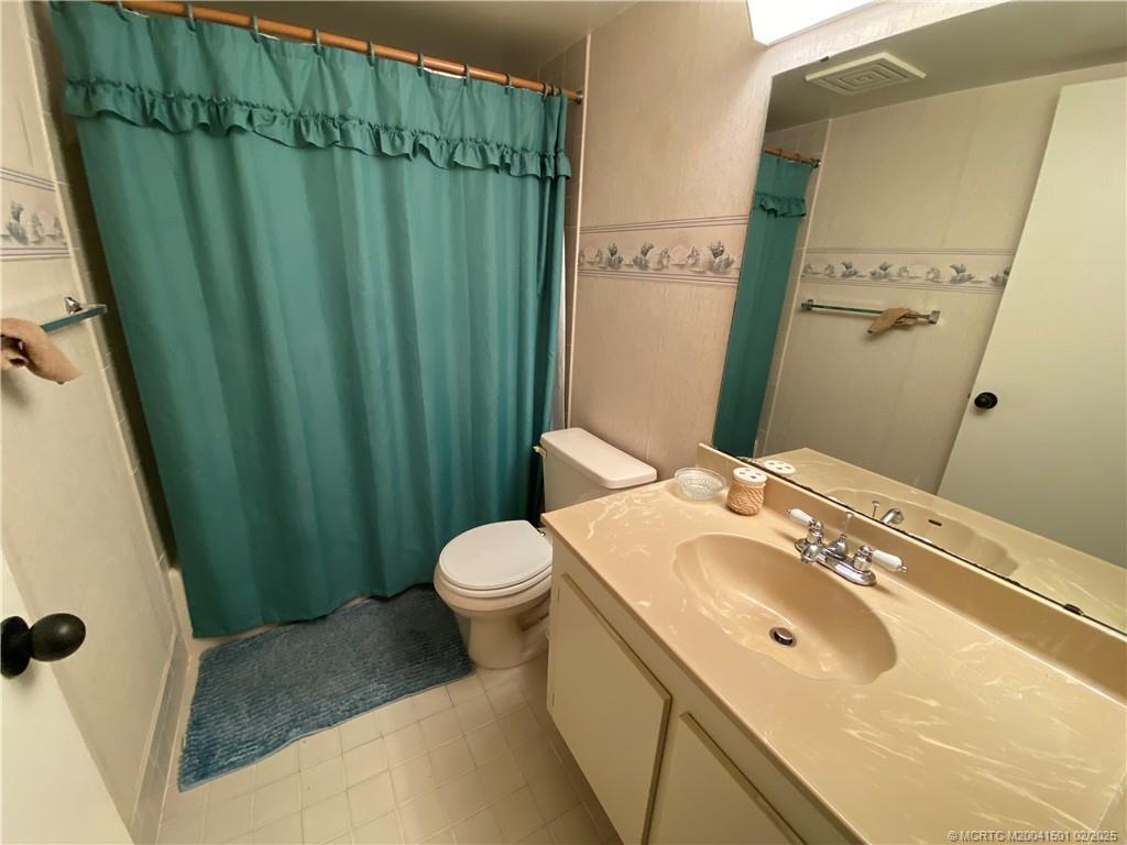 4620 Northeast Sandpebble Trace, Unit 405 Stuart, FL 34996 - Photo 21 of 26 a bathroom with a sink and toilet