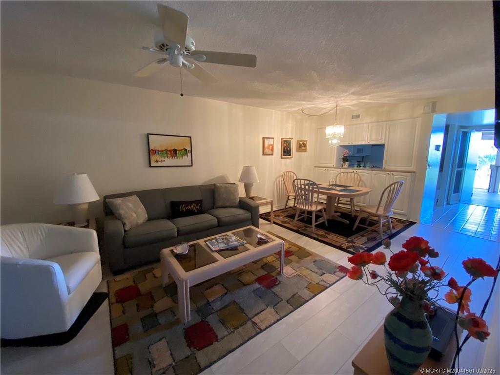 4620 Northeast Sandpebble Trace, Unit 405 Stuart, FL 34996 - Photo 6 of 26 a living room with furniture a rug and a window