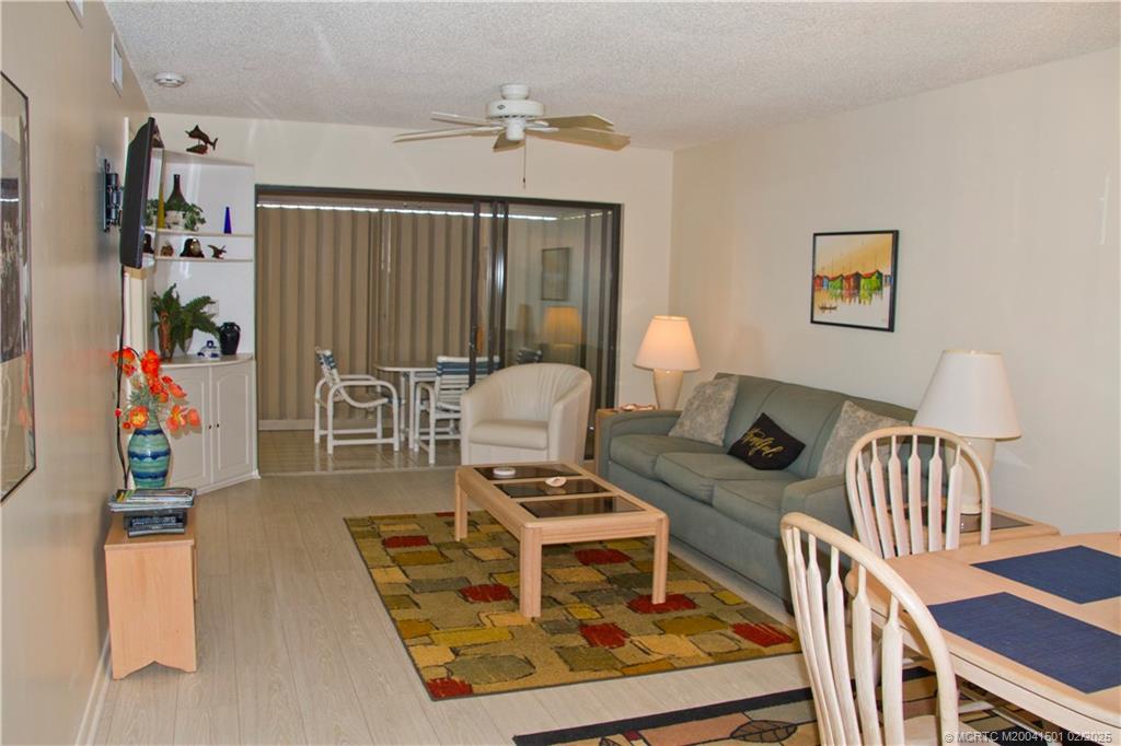 4620 Northeast Sandpebble Trace, Unit 405 Stuart, FL 34996 - Photo 7 of 26 a living room with furniture and a wooden floor