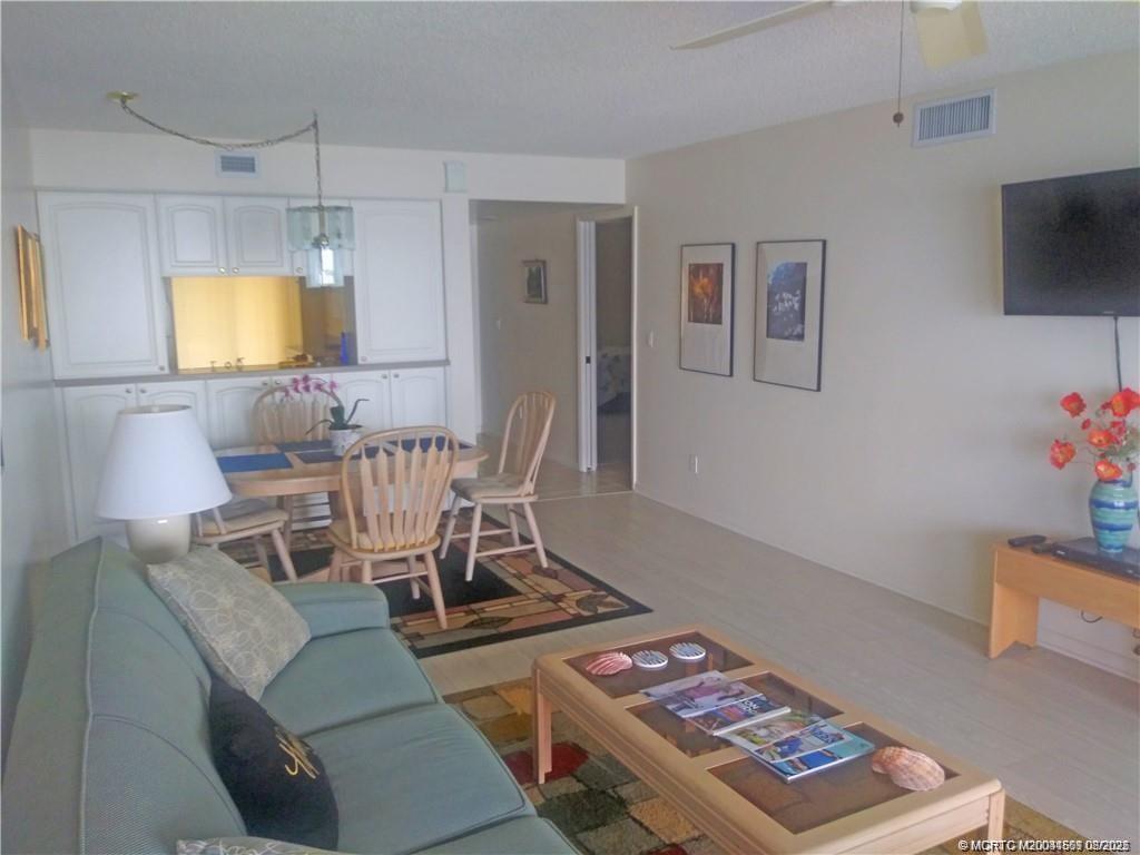 4620 Northeast Sandpebble Trace, Unit 405 Stuart, FL 34996 - Photo 9 of 26 a living room with furniture and a flat screen tv