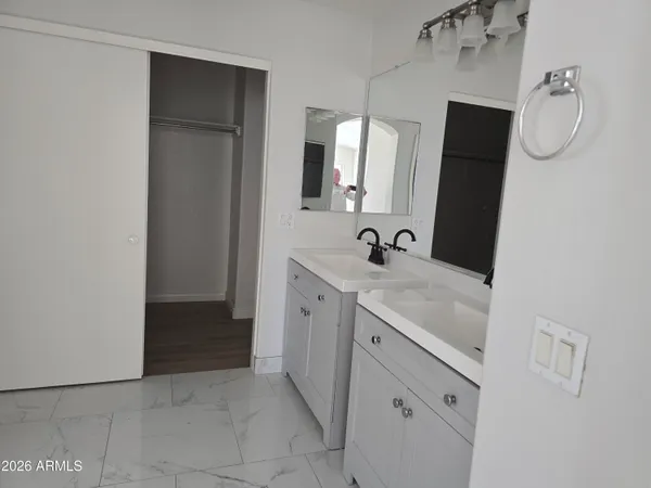 a spacious bathroom with a double vanity sink and mirror