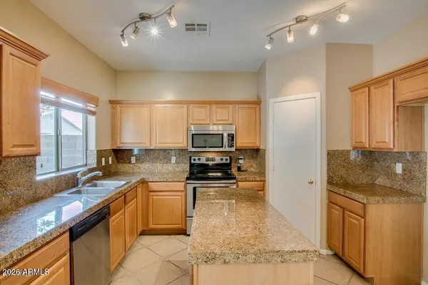 a kitchen with stainless steel appliances granite countertop a sink stove and refrigerator