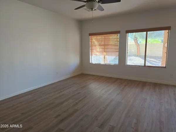 an empty room with wooden floor and windows