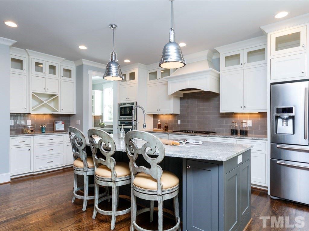 5015 Langley Circle Raleigh, NC 27609 - Photo 6 of 25 a kitchen with stainless steel appliances granite countertop a stove a refrigerator a oven a sink with a dining table and chairs