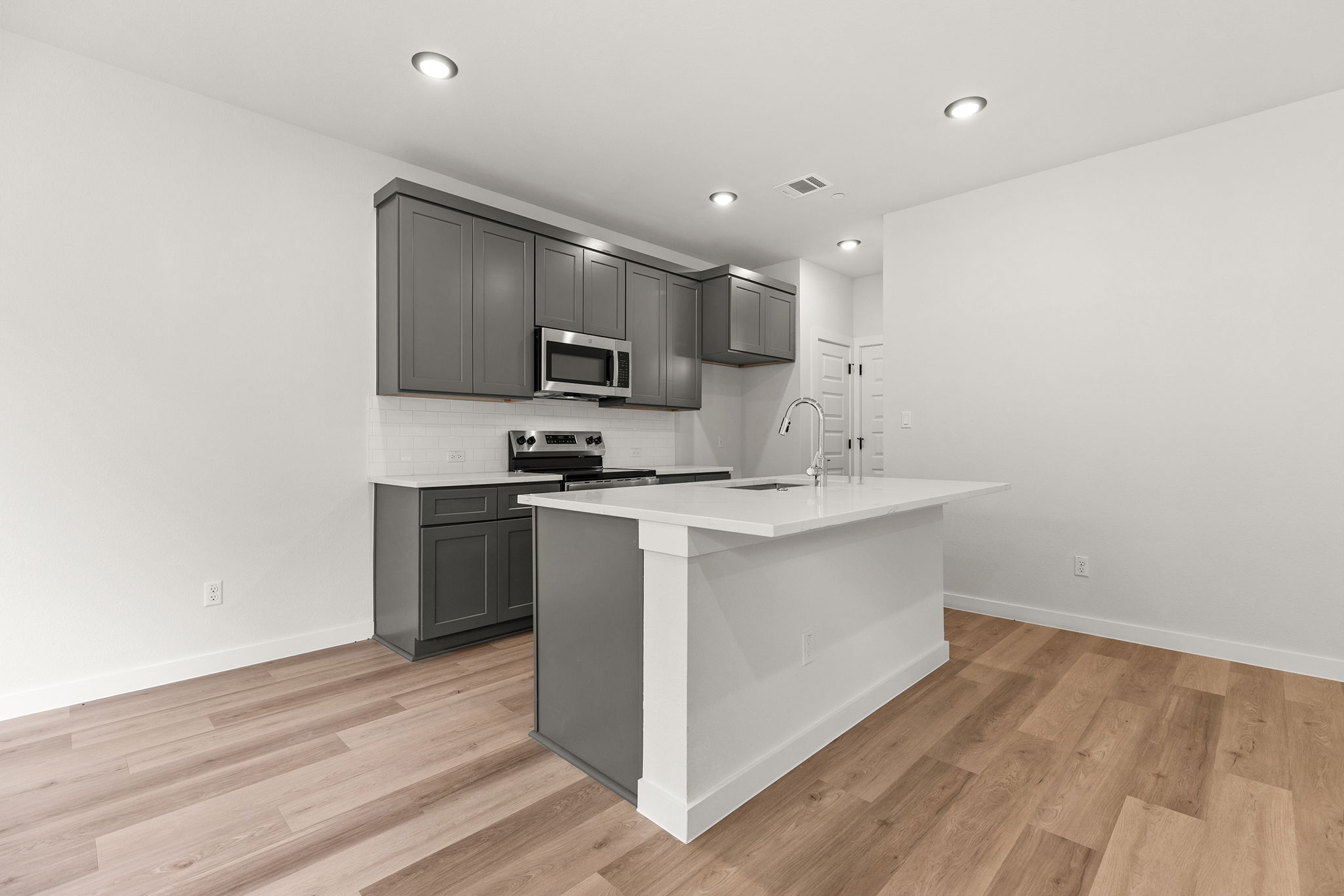 2600 Gattis School Road, Unit 1002 Round Rock, TX 78664 - Photo 6 of 40 Modern kitchen with sleek cabinetry, a center island, and wood-look flooring perfect for entertaining.