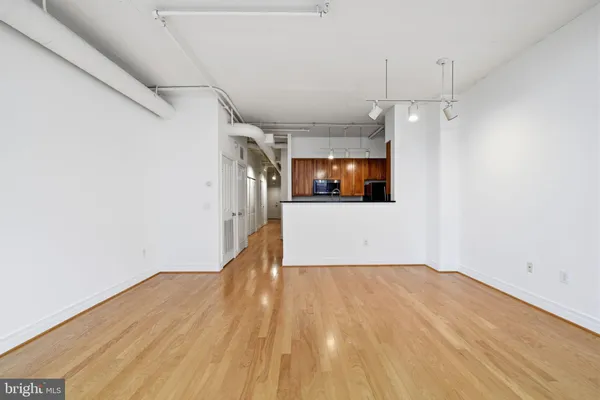 a view of a room with wooden floor and a ceiling fan