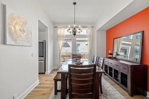 a dining room with furniture a chandelier and wooden floor