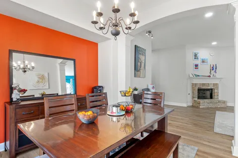 a view of a dining room with furniture a chandelier and wooden floor