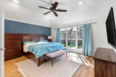 a bedroom with a large bed and a flat tv screen on dresser