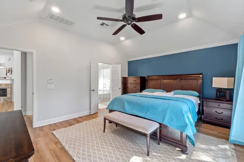 a bedroom with a bed lamps and a dresser