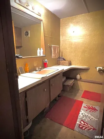 a bathroom with a sink toilet and a mirror