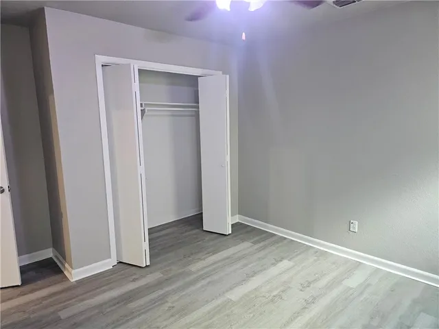 an empty room with wooden floor and closet