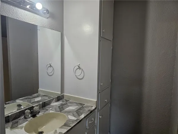 a bathroom with a granite countertop sink and a mirror