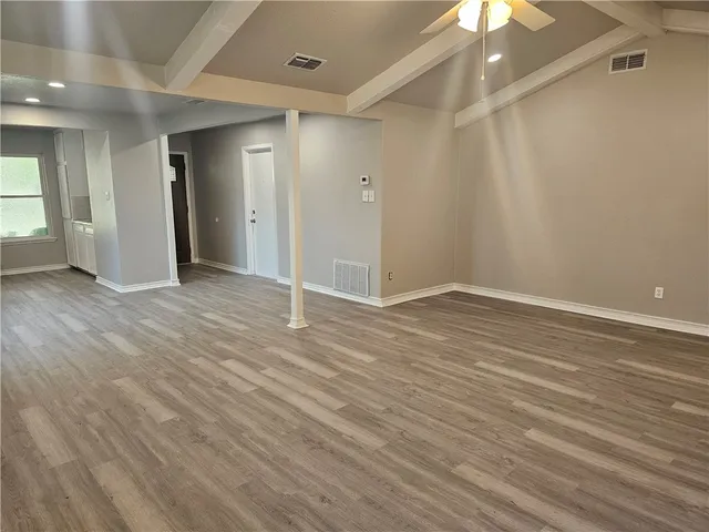 a view of an empty room with wooden floor