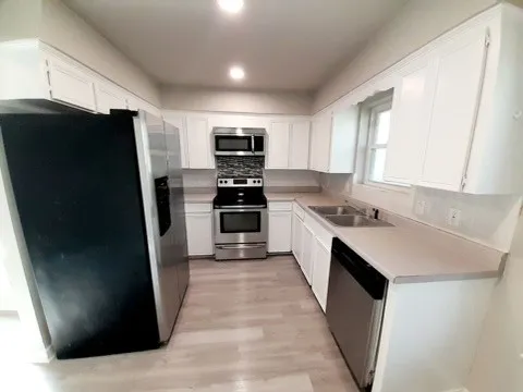 a kitchen with a sink stove and cabinets