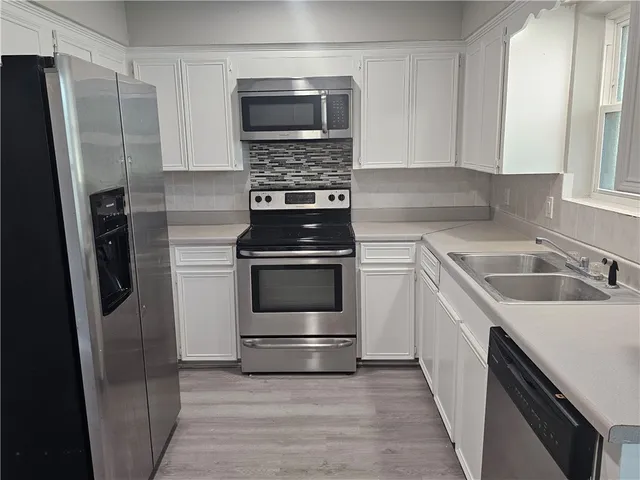 a kitchen with white cabinets and white appliances