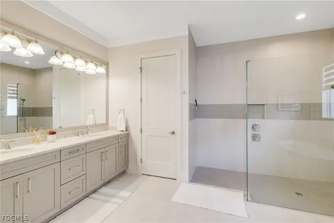 a spacious bathroom with a shower sink and mirror