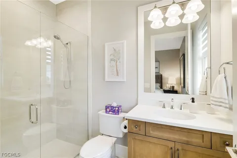 a bathroom with a sink vanity mirror and toilet