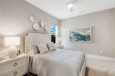 a bedroom with a bed and a lamp on dresser
