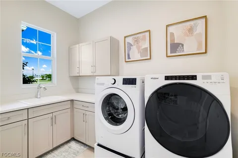 a utility room with sink dryer and washer