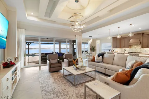 a living room with furniture kitchen view and a chandelier