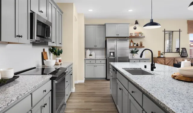 a kitchen with stainless steel appliances granite countertop a sink a stove and cabinets