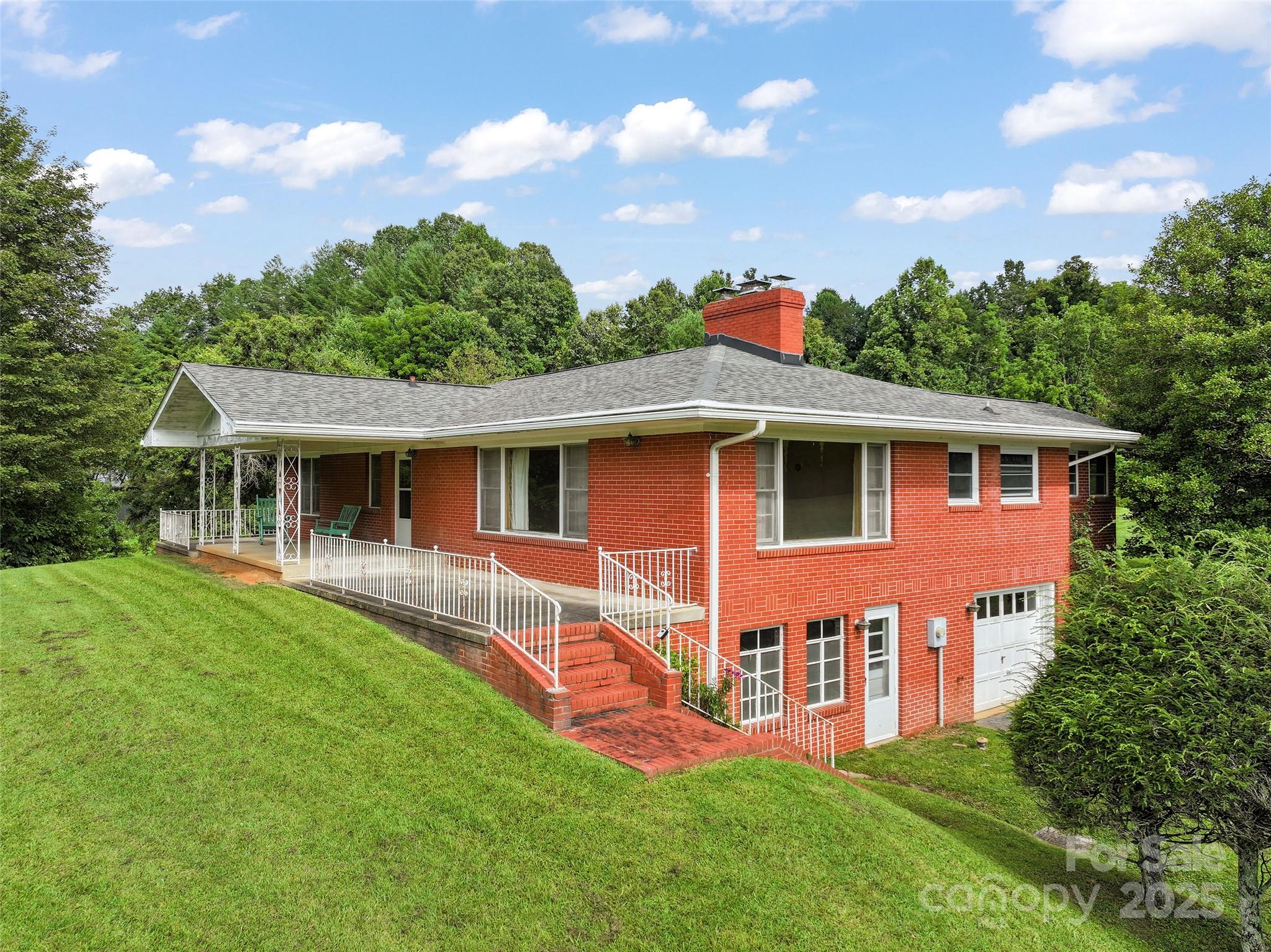 5 Noland Downs Road Waynesville, NC 28785 - Photo 2 of 33 a front view of a house with a garden