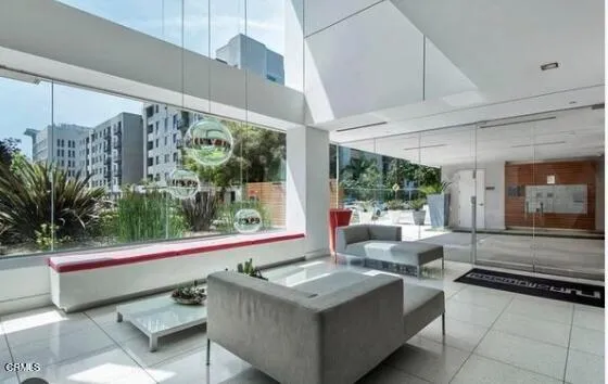 a living room with large window and furniture